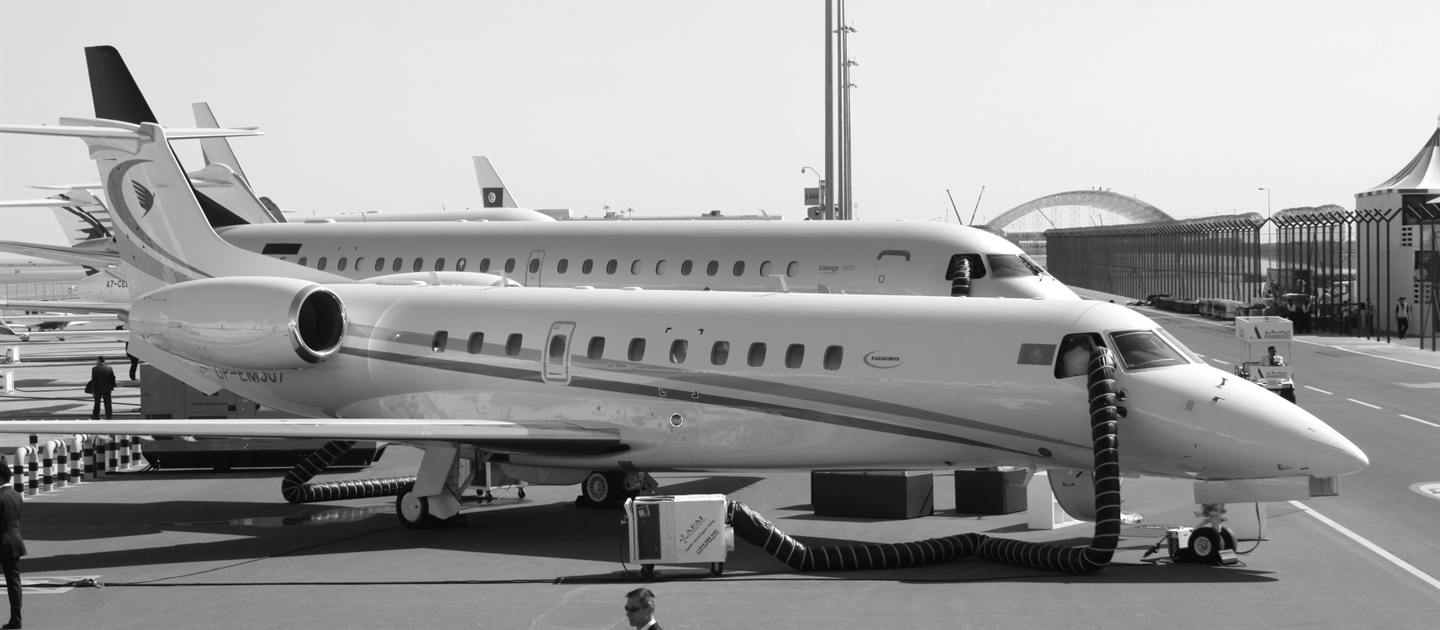 Un jet ejecutivo Embraer Legacy 650 estacionado en una plataforma aeroportuaria